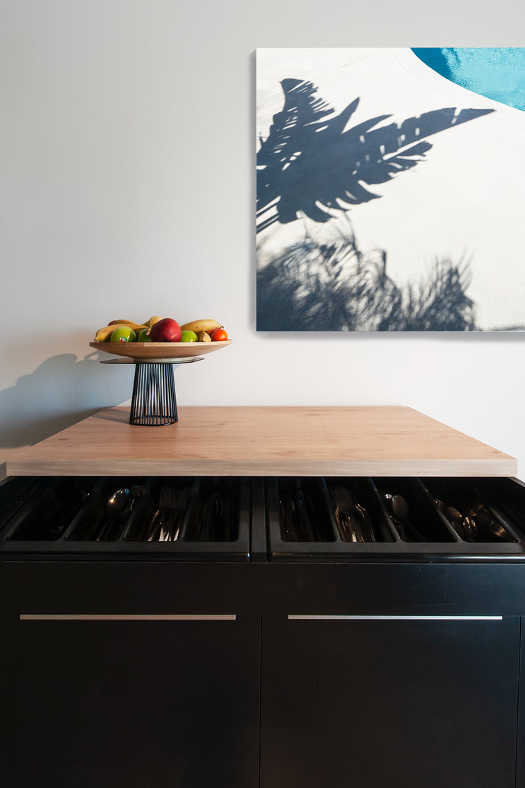 Shiny cutlery in the drawers and an equally attractive HPL worktop above this china cabinet
